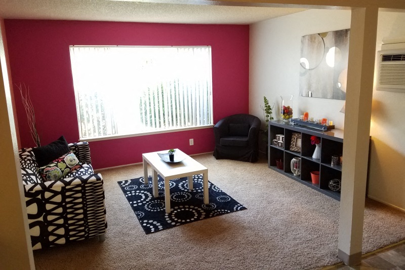 a living room with a red wall and a table