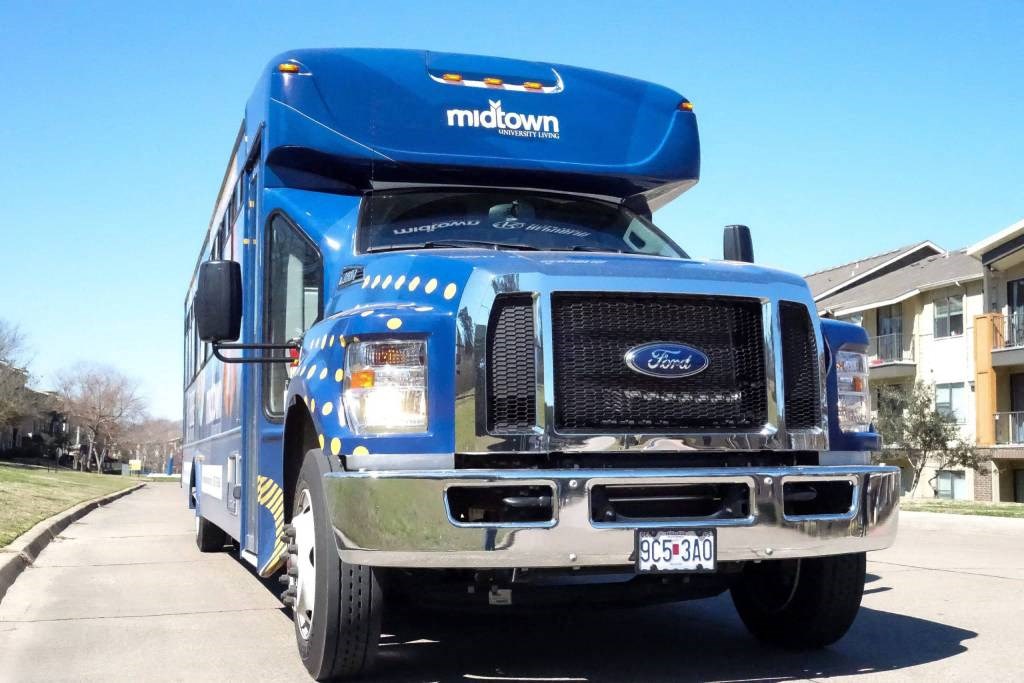 A blue bus parked at Midtown Sam Houston Apartments, Texas