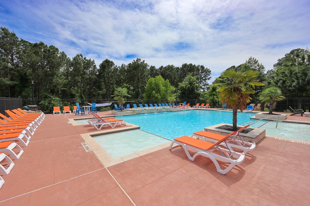 A Pool With Orange Chairs at Midtown Sam Houston Apartments, Huntsville, TX, 77340