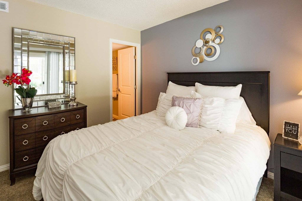 a bedroom with a large bed and a dresser