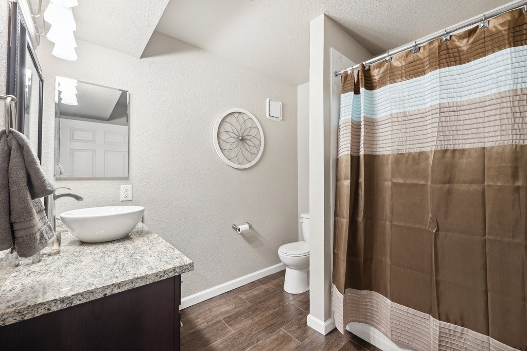 a bathroom with a shower and a toilet and a sink