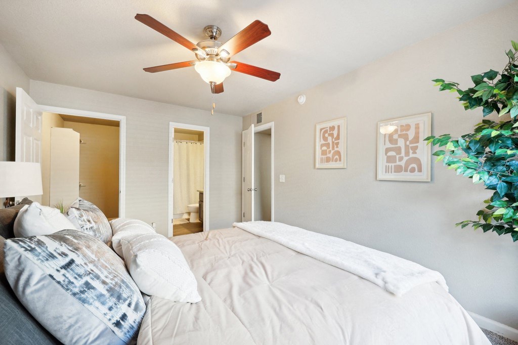 the master bedroom has a large bed and a ceiling fan