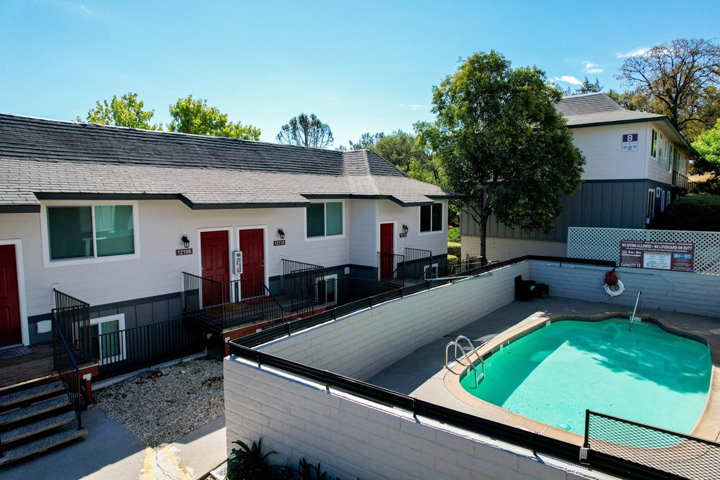 Exterior view of a building and gated community pool at Persimmon Terrace