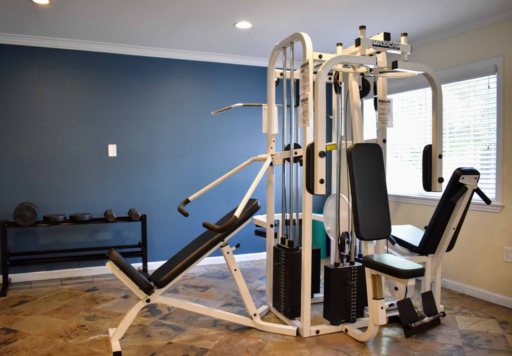 Community gym View of community gym with free weights, weight machine, and well lit window