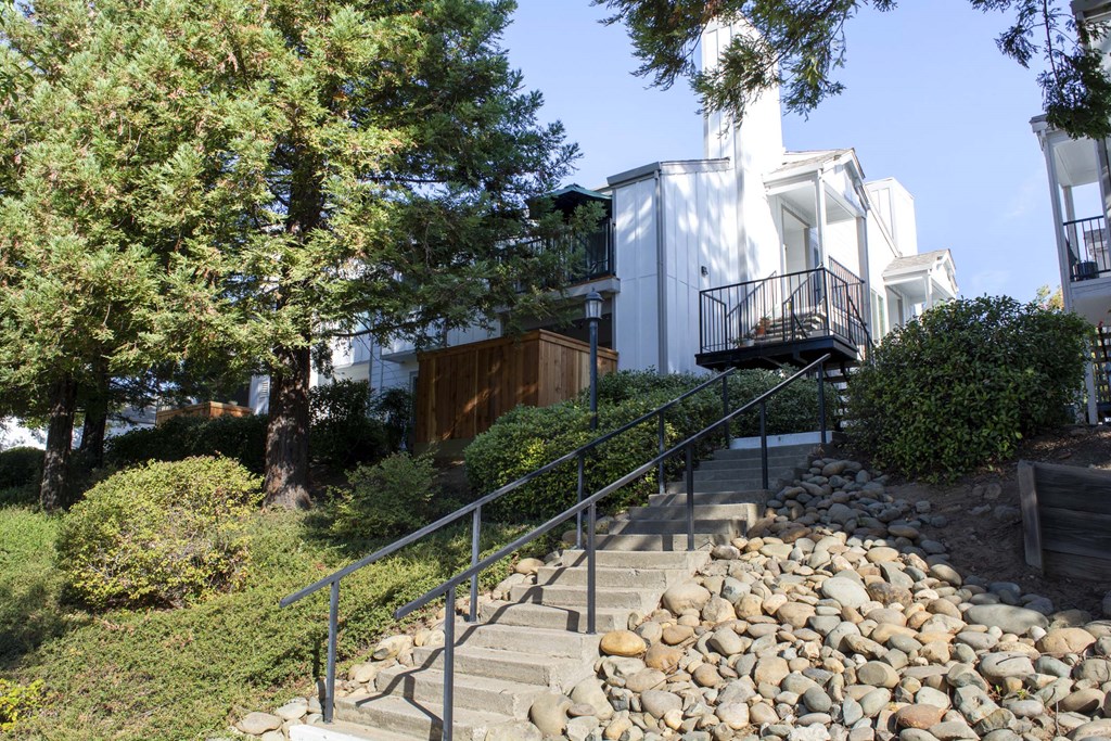 View from lower level of well landscaped exterior of building with private patio/balcony