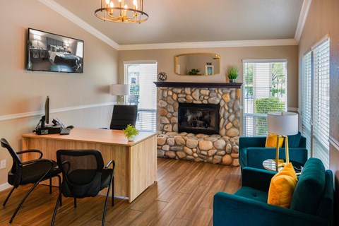 A room with a stone fireplace and a green couch.