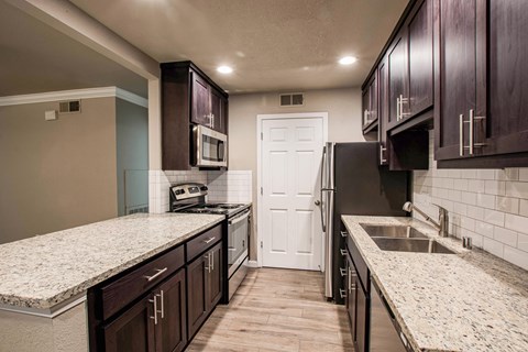 a kitchen with marble counter tops and wooden cabinets