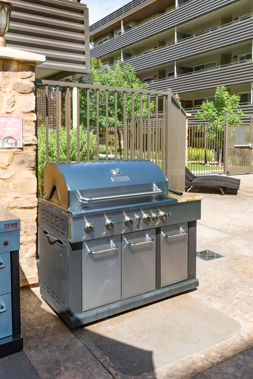 a stainless steel grill on a sidewalk in front of a building