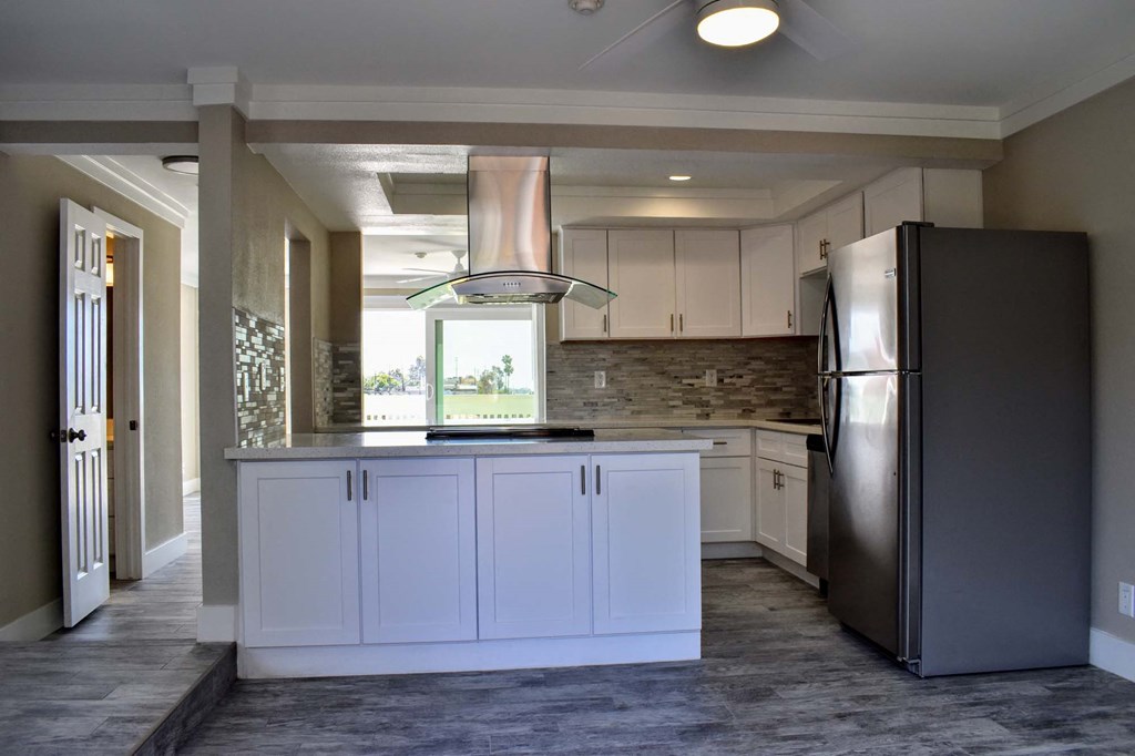 kitchen with marble counters, tile back splash and stainless appliances