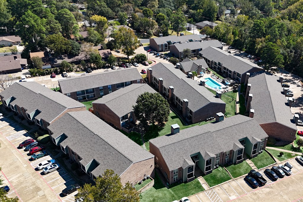 an aerial view of a building with cars parked in a parking lot