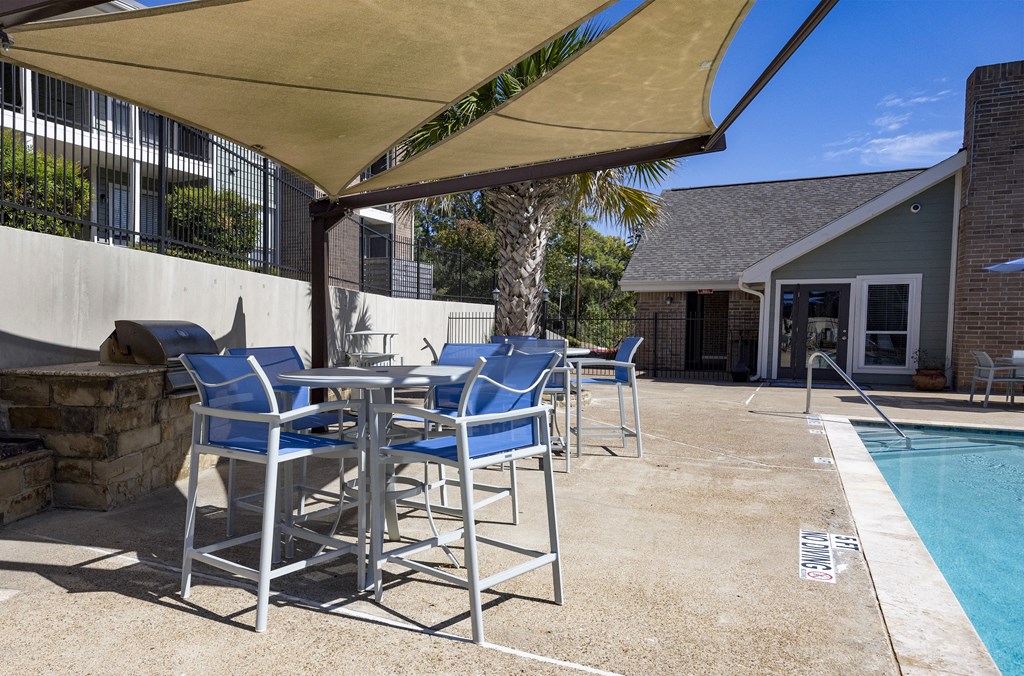 a patio with chairs and tables and a swimming pool
