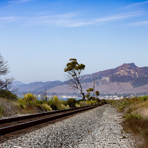 a train track with a mountain in the background