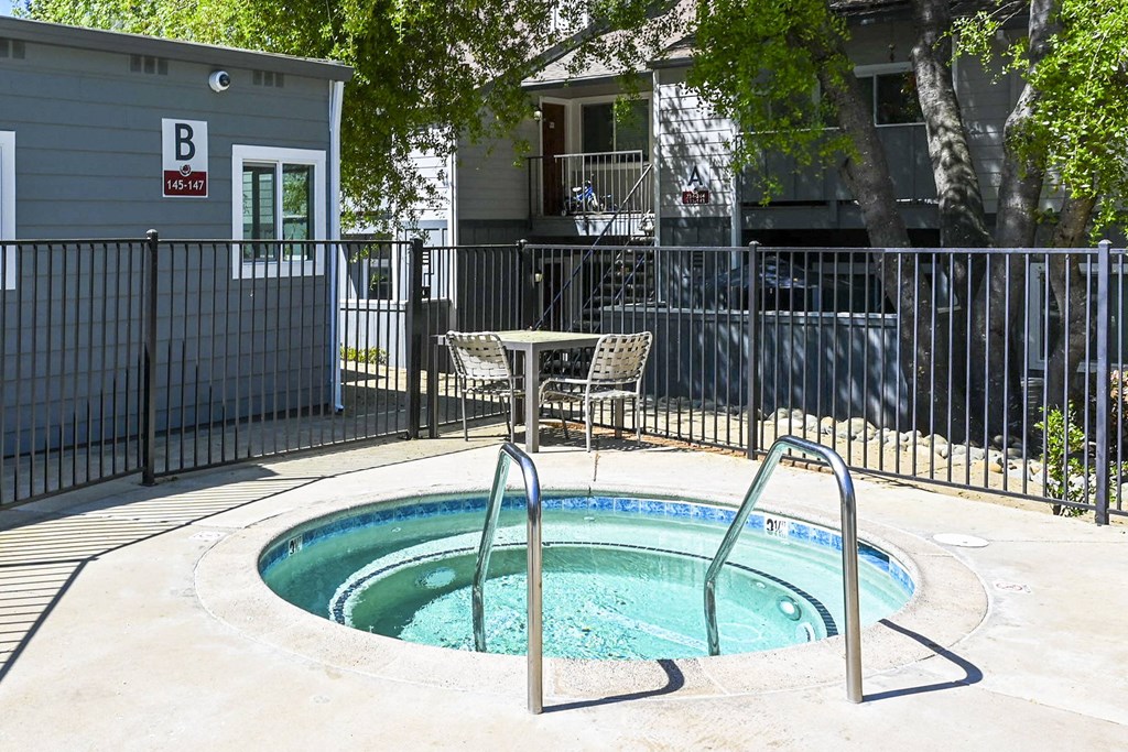 a hot tub with a table and chairs next to it at Sierra Oaks Living Apartments, Cameron Park