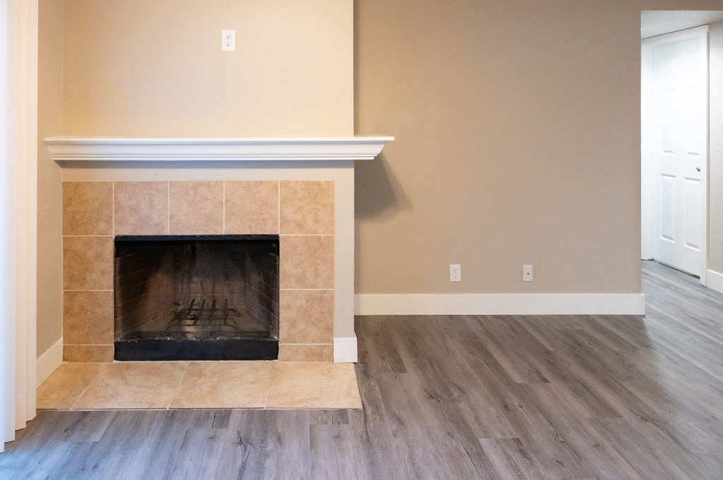 the living room with a fireplace and a wooden floor at Sierra Oaks Living Apartments, California 95682