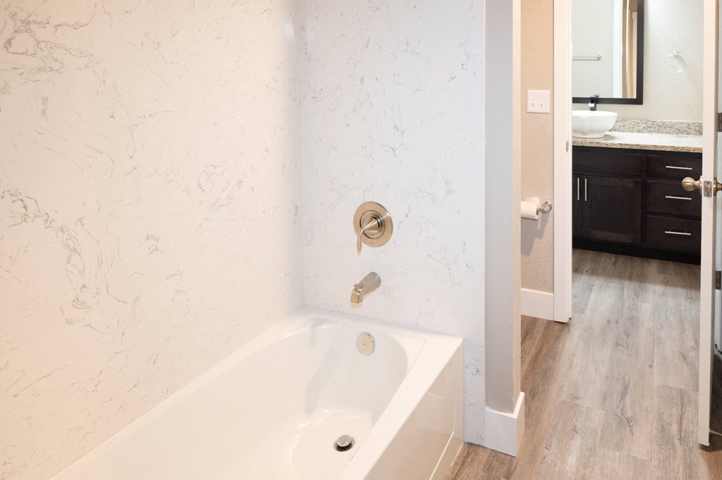 a bathroom with a tub and a sink and a mirror at Sierra Oaks Living Apartments, Cameron Park 95682