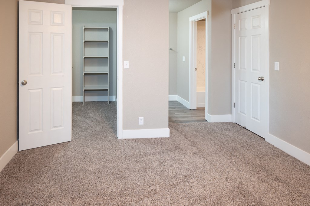 an empty room with a carpeted floor and a closet at Sierra Oaks Living Apartments, Cameron Park 95682