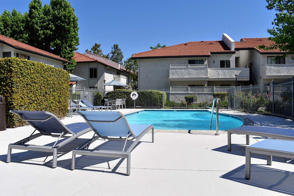 View of pool, lounge chairs, and exterior of buildings