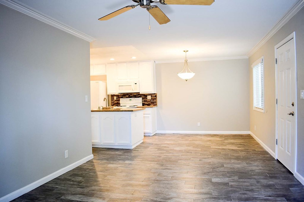 View of living space with wood look flooring, partial view of kitchen