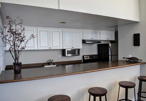 A kitchen with white cabinets and a brown counter.