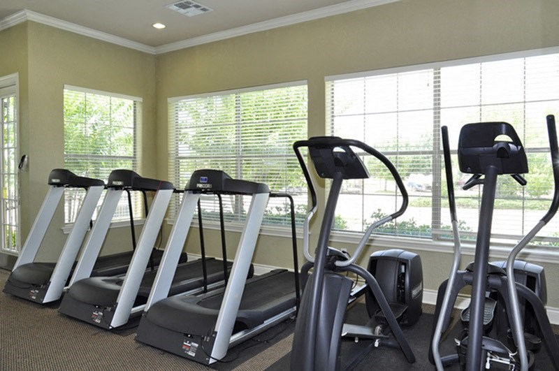 View of community fitness center with elliptical and treadmills