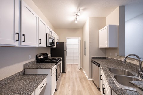 the preserve at ballantyne commons apartment kitchen with granite counter tops and white cabinets