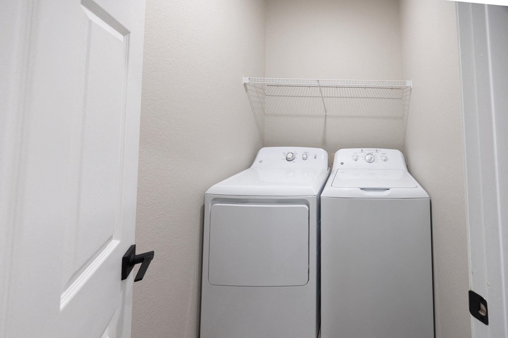 a washer and dryer in a laundry room with a white door