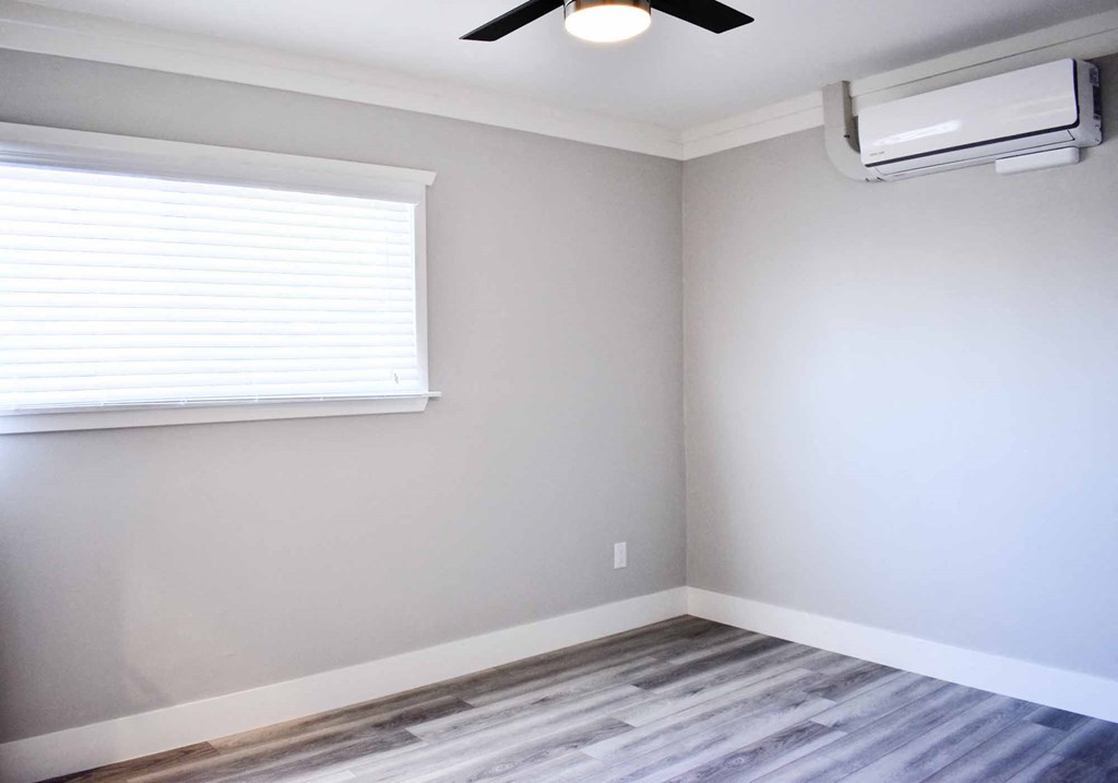 bedroom with wood look flooring, ceiling fan, and well lit window