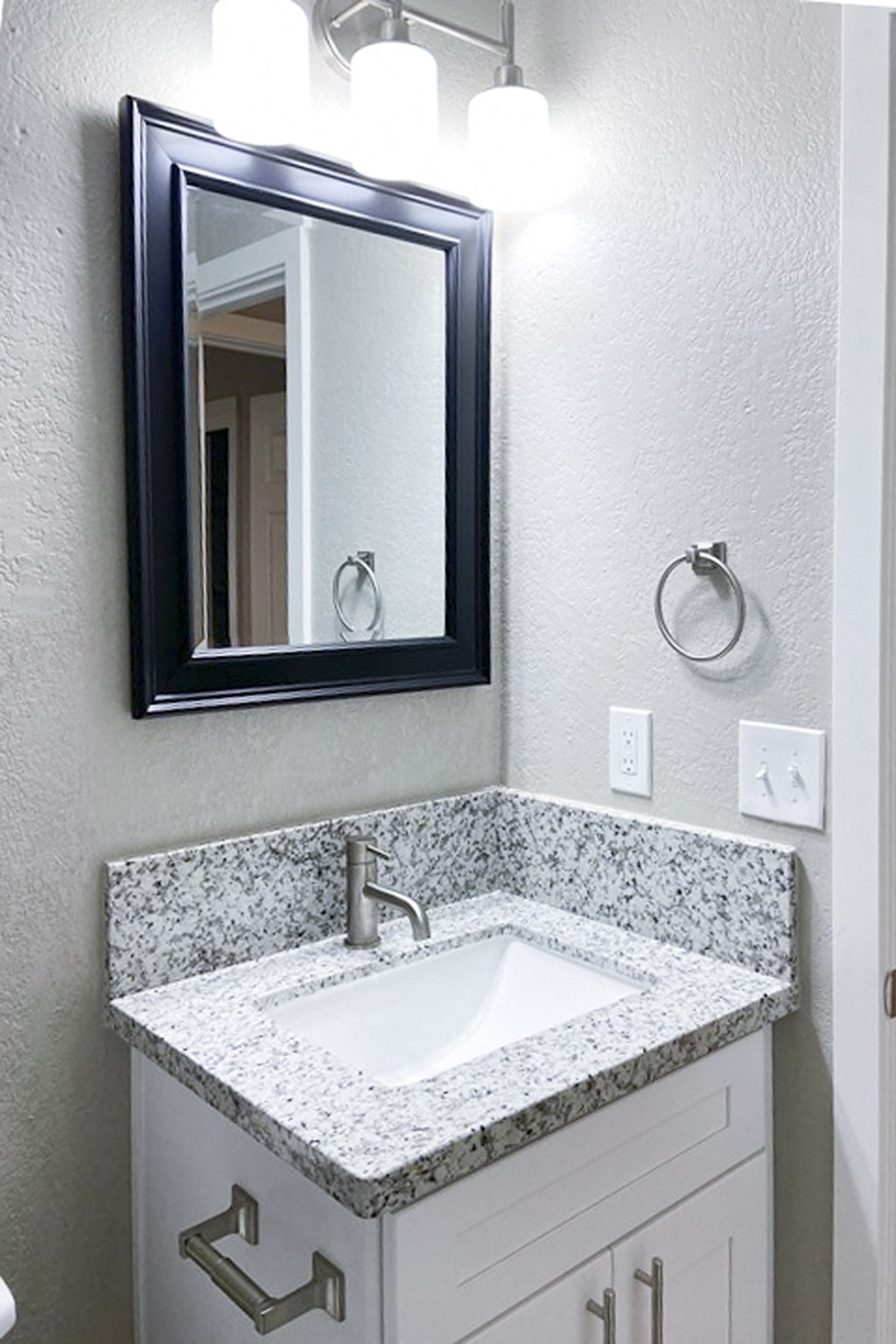 bathroom vanity with in laid sink, mirror, and lighting