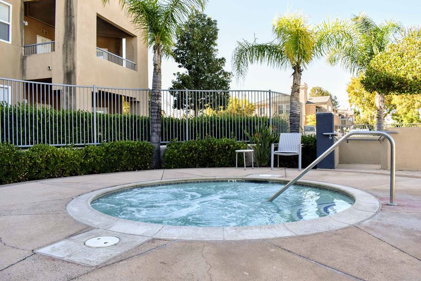 community spa a hot tub with a railing in front of an apartment building