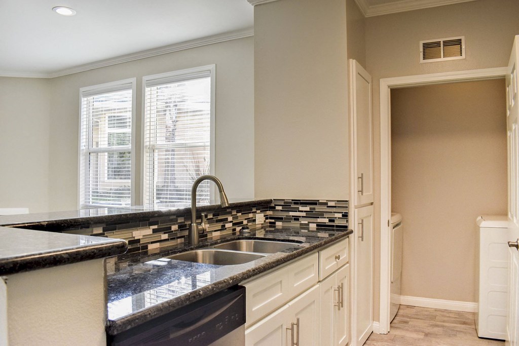 kitchen with dark countertops, in laid sink, and stainless appliances.