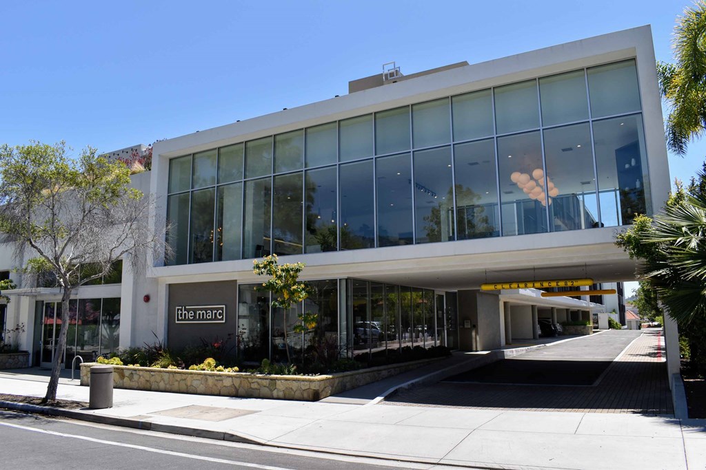an office building with large glass windows and a sidewalk