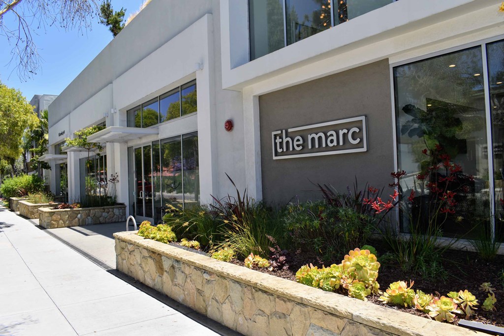 the marc building entrance with sidewalk and plants