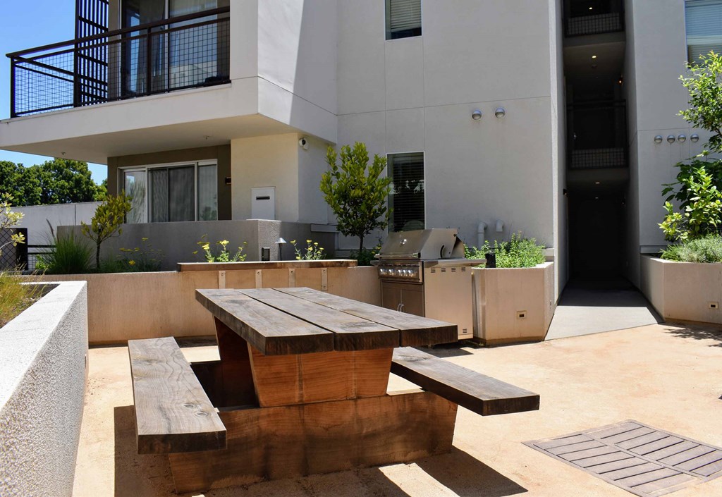 a picnic table and benches in a courtyard