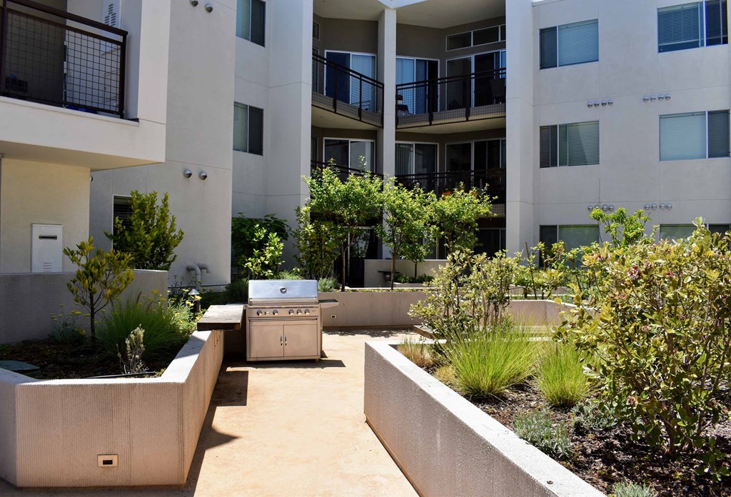 a courtyard with a grill in front of an apartment building