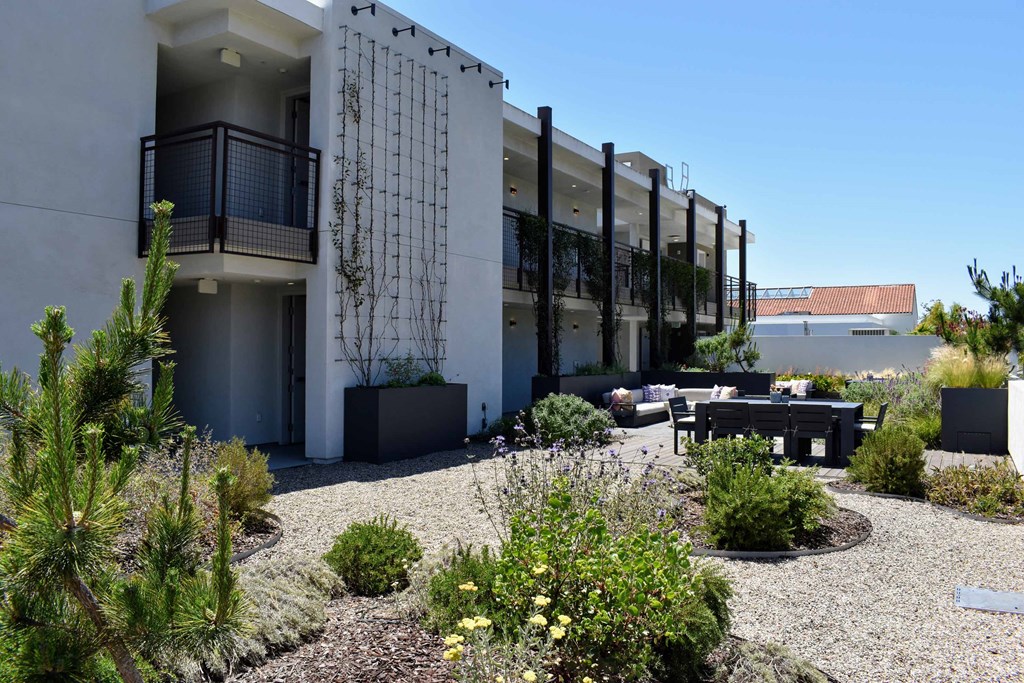 a building with a patio and plants in front of it