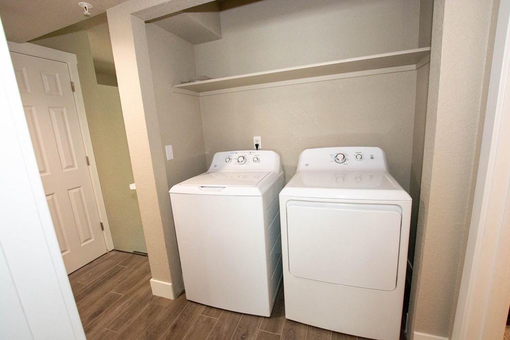 an empty laundry room with two washes and a dryer
