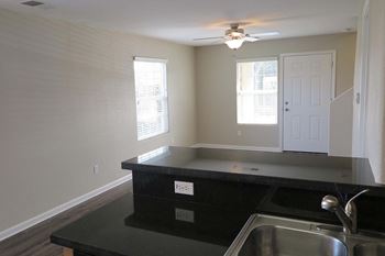 view of living room from the kitchen showing a stainless sink and dark counter tops