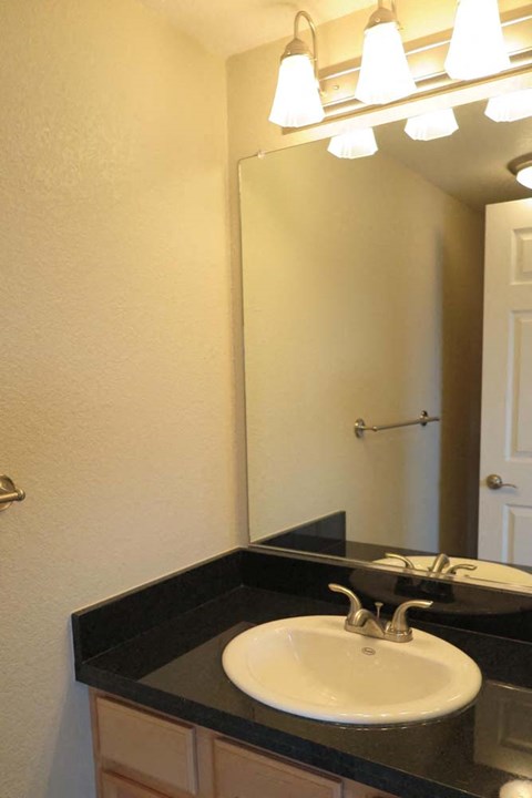 bathroom vanity and four bulb light fixture