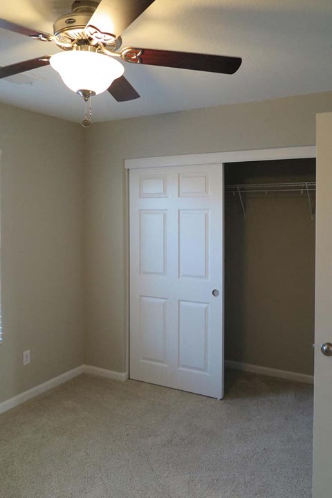 View of bedroom with ceiling fan  and closet