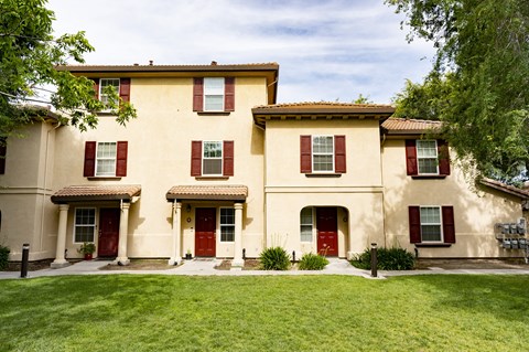 building at Tuscana with a lawn and trees in front of it