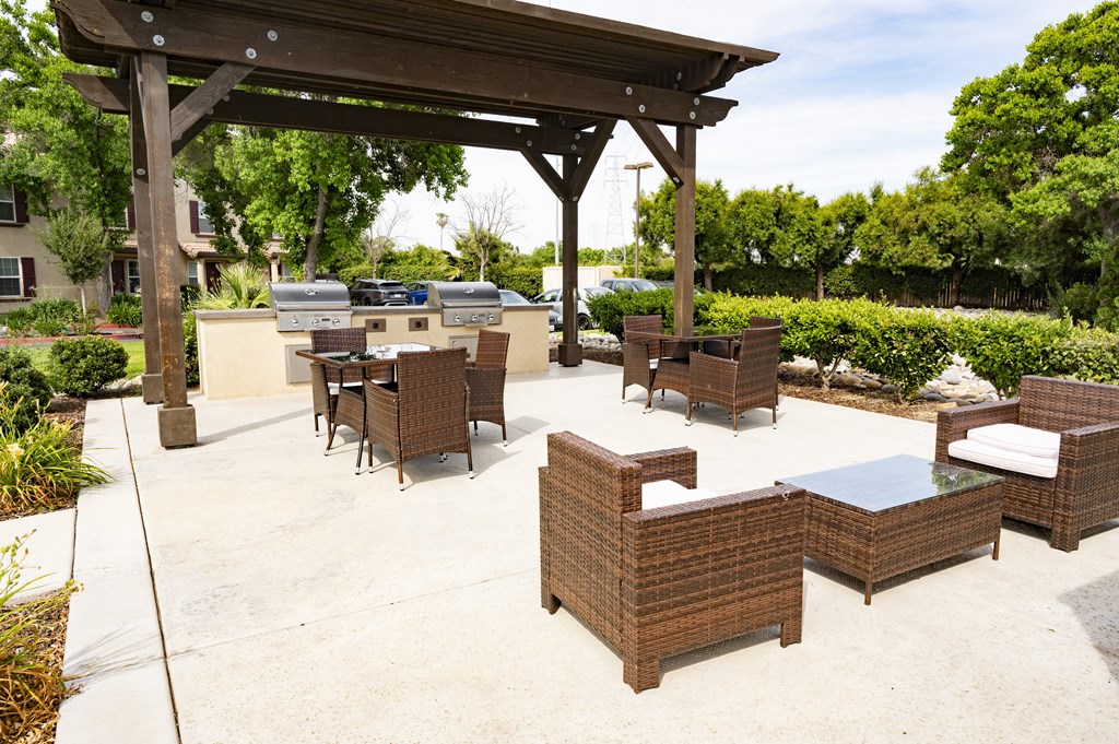 a large outdoor patio with a pergola and barbecue grill