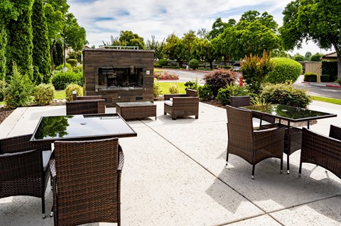 an outdoor patio with tables and chairs and a fire place