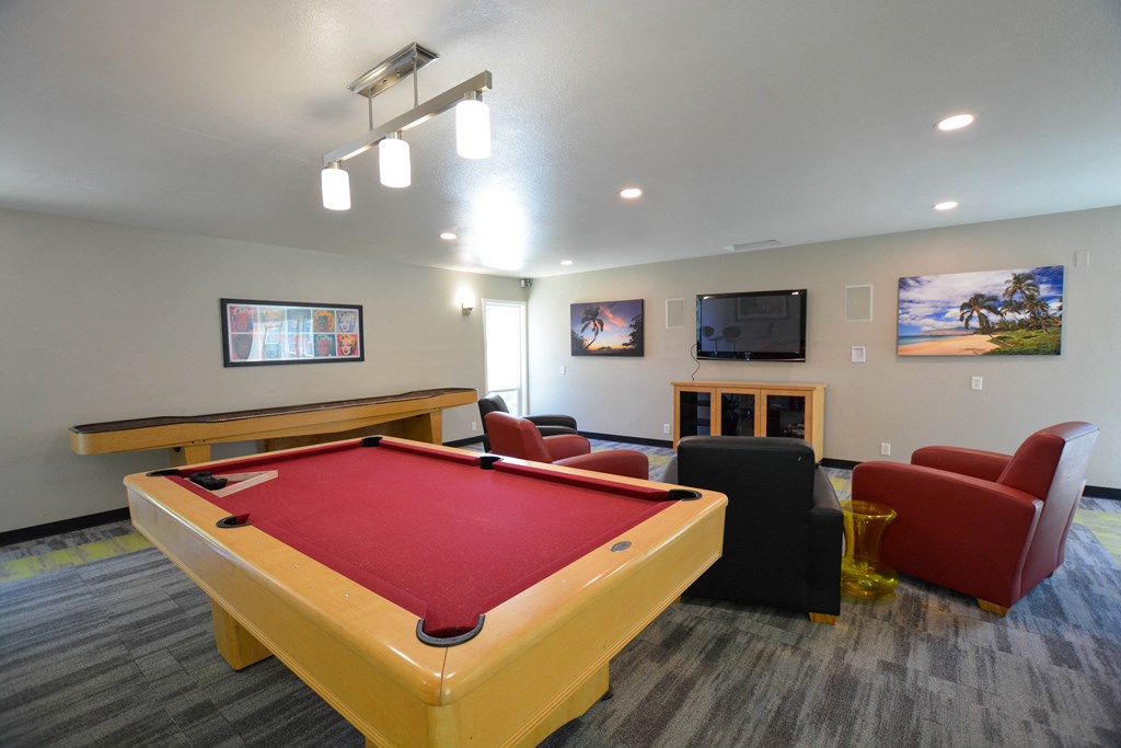 a game room with a pool table and chairs