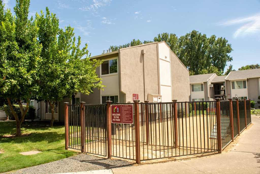 an apartment building with a fence and a sign in front of it