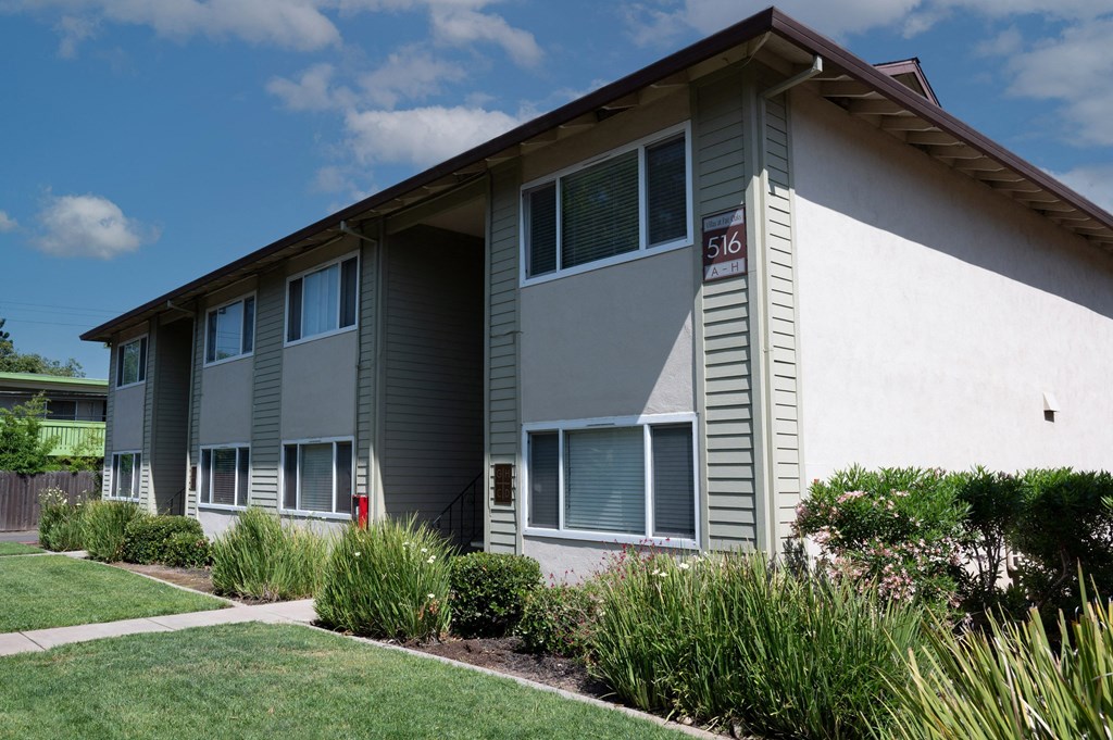View of exterior building at Villas at Fair Oaks with lush shrubbery surrounding building