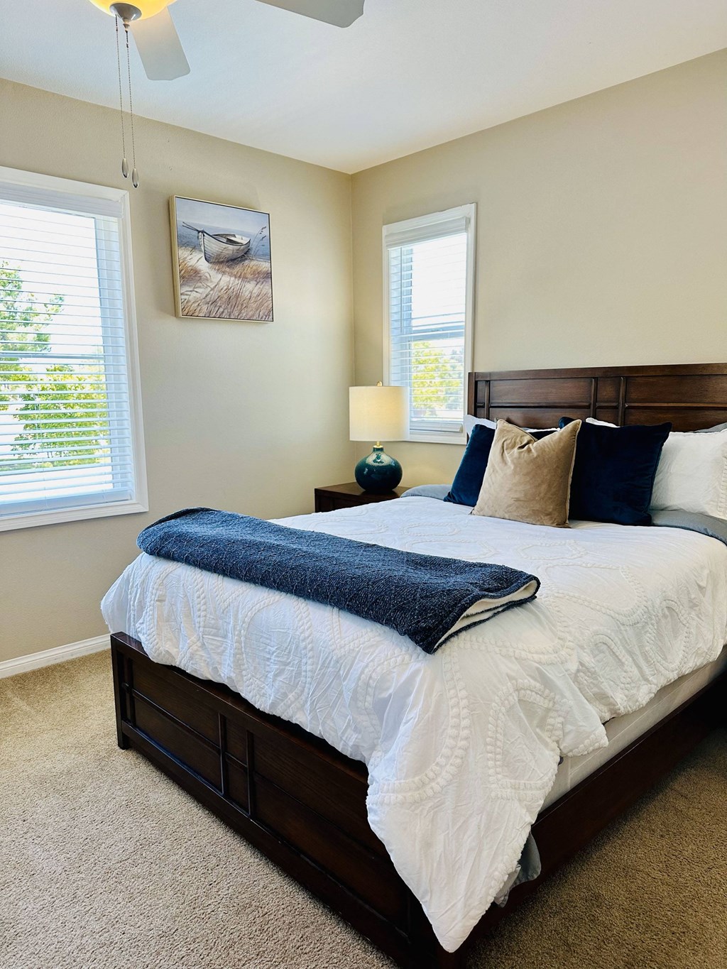 a bedroom with a bed and two windows