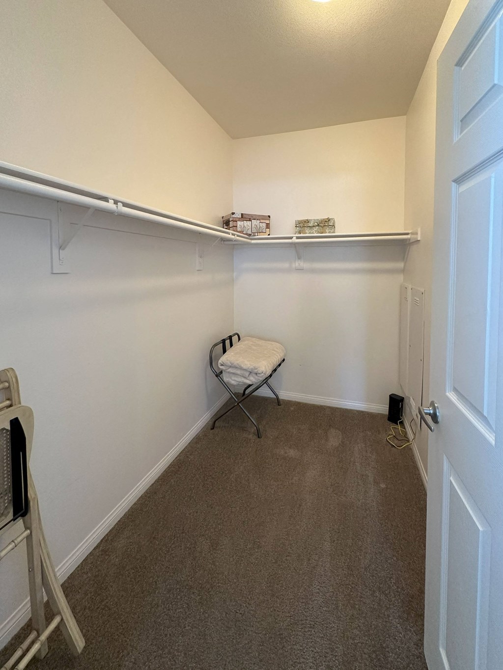 a room with a chair and a shelf on the wall