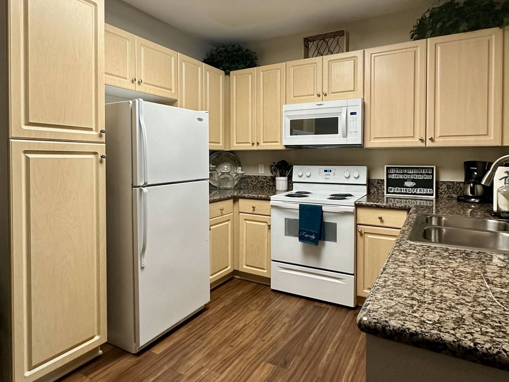 a kitchen with white appliances and wooden cabinets