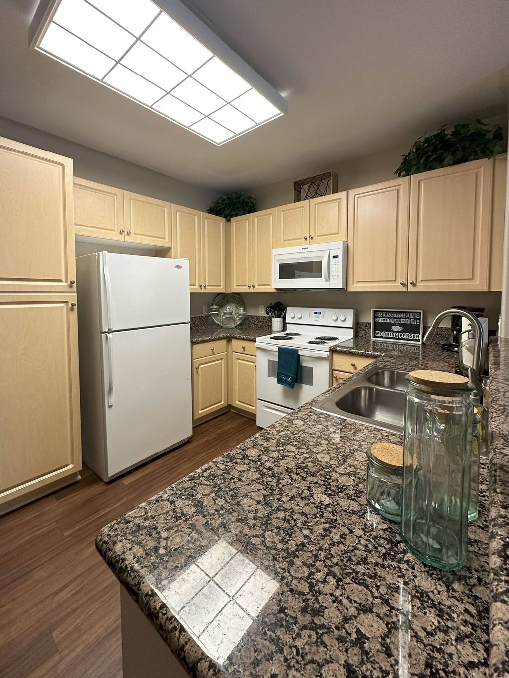 a kitchen with white appliances and granite counter tops