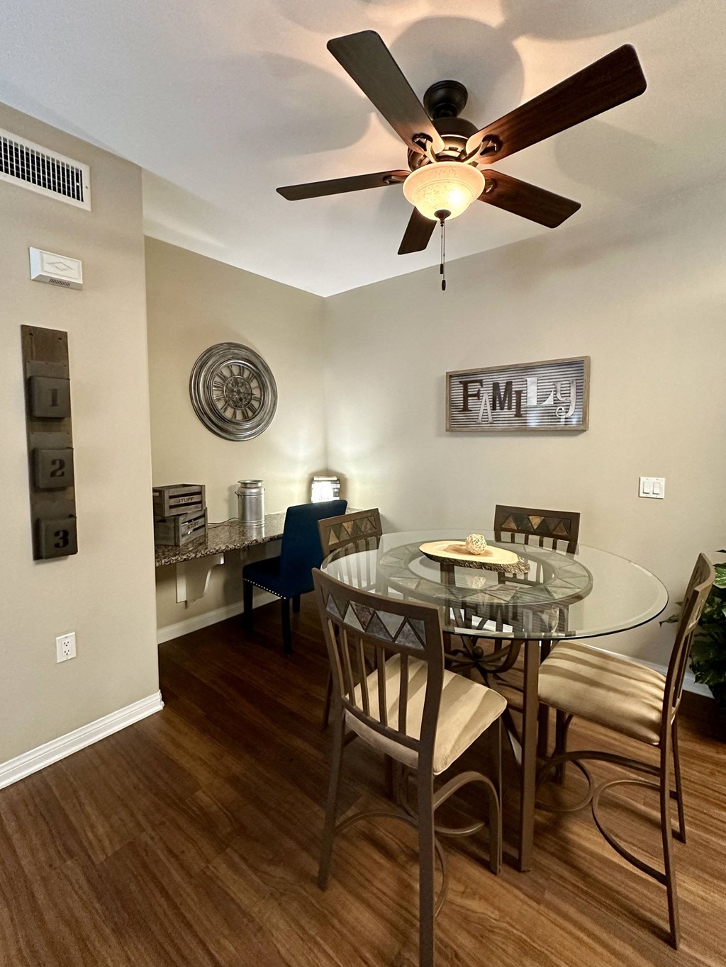 a dining room with a glass table and a ceiling fan